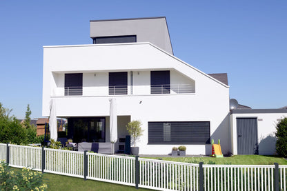 Railingzaun mit 35er Latte in weiß mit Pfosten in anthrazit - schräger Verlauf vor weißem Haus