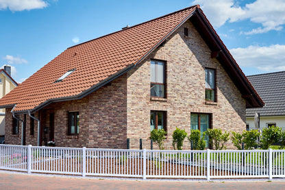 Railingzaun weiß mit 35er Latte und Pfosten anthrazit vor Haus mit Backstein Fassade