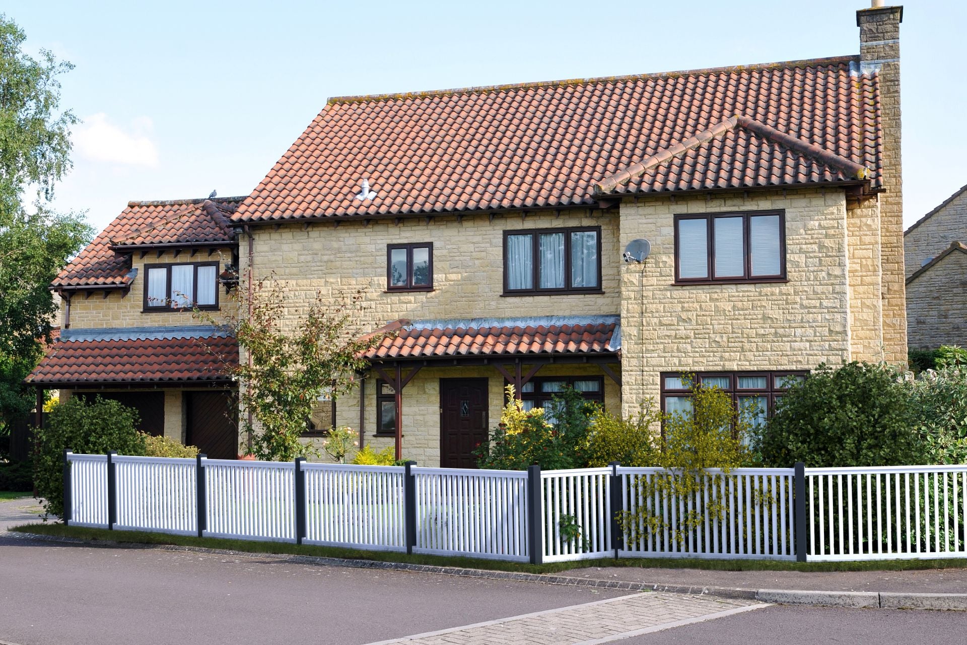 Railingzaun weiß mit 35er Latte und Pfosten anthrazit vor gelbem Haus