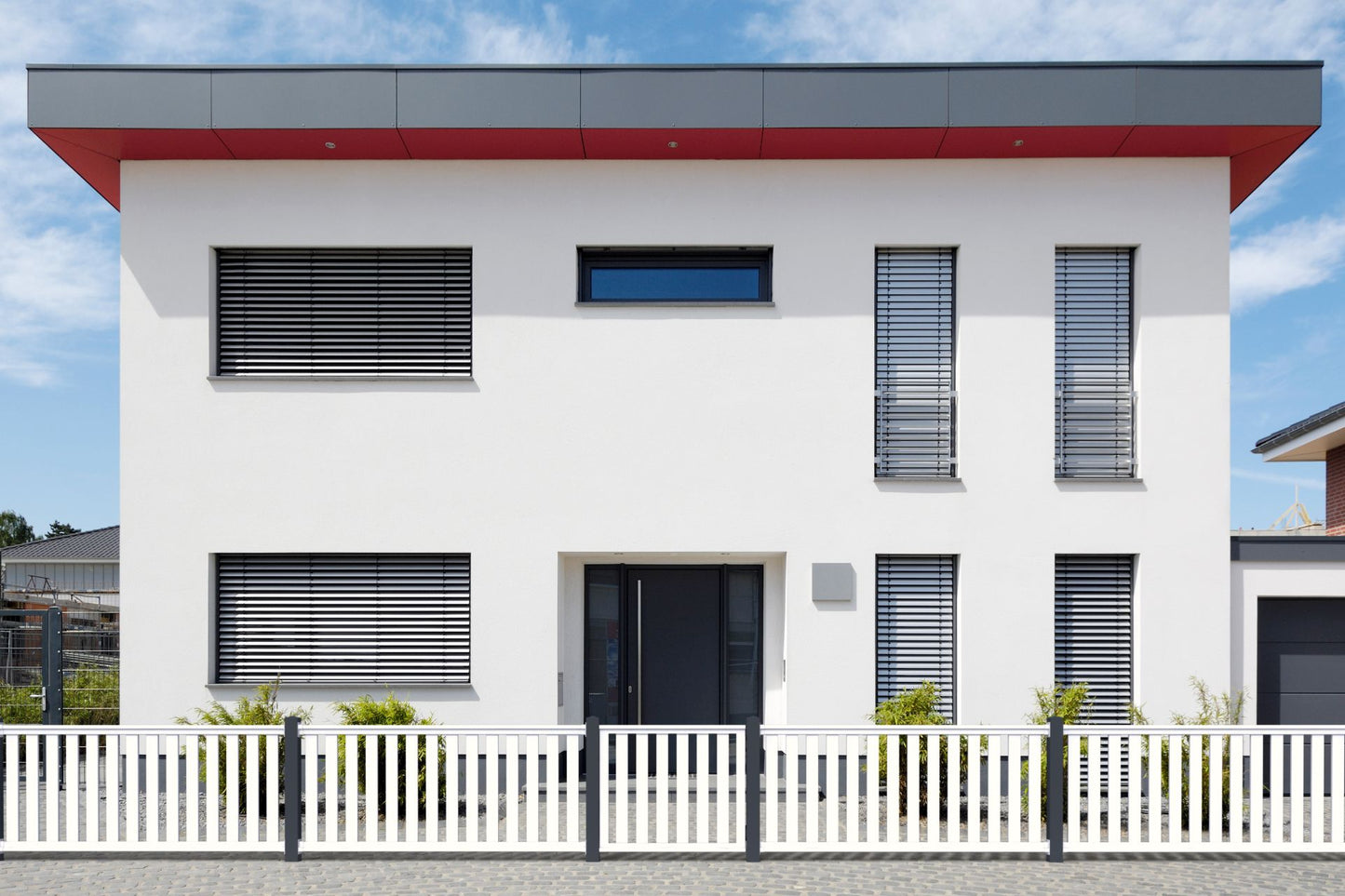 Railingzaun weiß mit 82er Latte und Pfosten anthrazit vor weißem Haus frontal