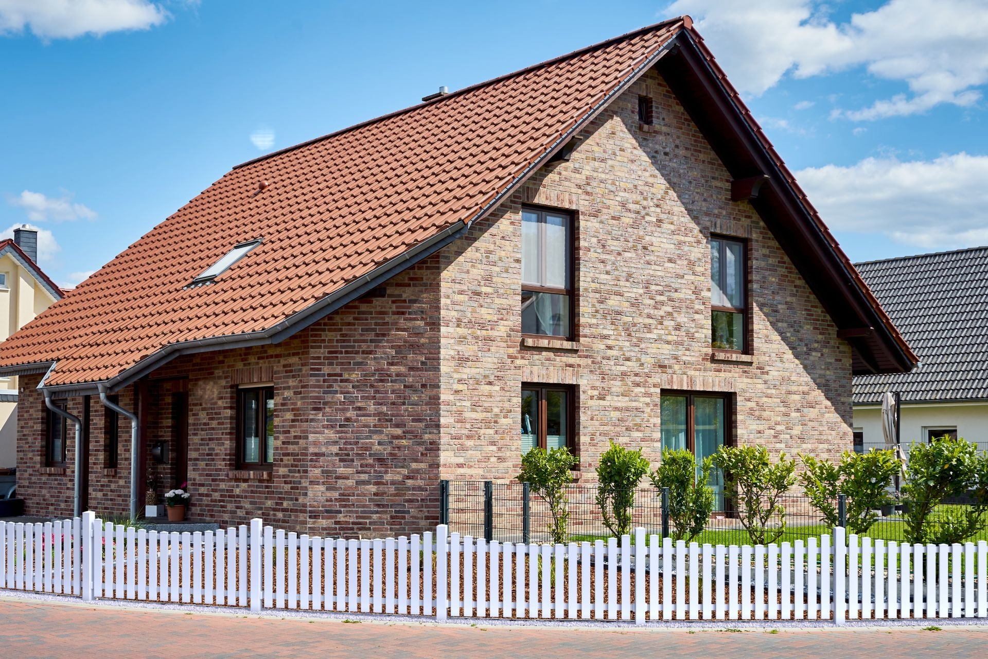 Vorgartenzaun Bogen unten mit Pfosten anthrazit vor Haus mit Backsteinfassade